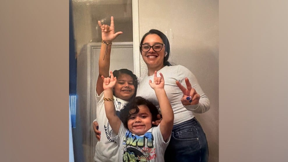 A photo of a mom with slight brown skin and her two kids posing for the camera
