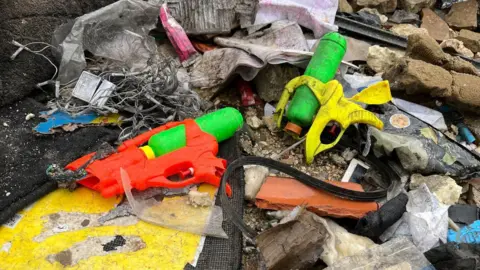 Two toy water guns amid the debris after the house was destroyed in a strike